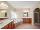Bright bathroom featuring double vanity, soaking tub, and separate glass-enclosed shower at 3125 Crooked Stick Dr, Cumming, GA 30041