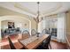 Elegant dining area featuring a wooden table, chandelier, and large window, perfect for gatherings and meals at 3125 Crooked Stick Dr, Cumming, GA 30041