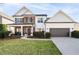 Charming two-story home showcasing a landscaped yard, stone accents, and an inviting covered front porch at 3125 Crooked Stick Dr, Cumming, GA 30041