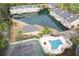 Aerial view of community featuring a pool, clubhouse, tennis court, and waterfront apartments at 14 Muncy Se Ct, Smyrna, GA 30080