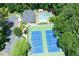 Aerial view of community pool and tennis courts surrounded by lush trees and parking at 14 Muncy Se Ct, Smyrna, GA 30080