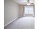 Empty bedroom featuring neutral colored walls, carpeted floors, a ceiling fan, and a large window at 14 Muncy Se Ct, Smyrna, GA 30080