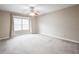 Empty bedroom with carpet, neutral walls, large window with drapes, and a ceiling fan at 14 Muncy Se Ct, Smyrna, GA 30080