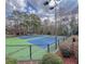 View of community tennis courts with an enclosed fence and nearby landscaping at 14 Muncy Se Ct, Smyrna, GA 30080