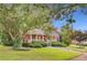 Beautiful brick home with a covered front porch, mature trees, and a well-maintained lawn at 1408 Aramore Dr, Conyers, GA 30013