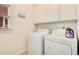 Functional laundry room with washer, dryer, and built-in cabinets at 1408 Aramore Dr, Conyers, GA 30013