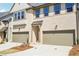 Charming townhome exterior with light brick, tan trim, two-car garage, and well-manicured landscaping at 3900 Allegretto Cir # 51, Atlanta, GA 30339