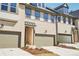 Attractive townhome exteriors featuring two-car garages, light brick, covered entryways, and clean landscaping at 3900 Allegretto Cir # 51, Atlanta, GA 30339