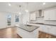 Open-concept kitchen with white cabinets, gray countertops, stainless steel appliances, and wood floors at 3900 Allegretto Cir # 51, Atlanta, GA 30339