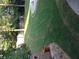 Landscaped backyard featuring lush green grass, mature trees, and a retaining wall with flowerpots at 222 Waterford Cove Dr, Suwanee, GA 30024