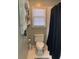 Bathroom including toilet, shelving, and shower with dark patterned curtain at 222 Waterford Cove Dr, Suwanee, GA 30024