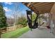 Relaxing covered back porch featuring a swing bed and a view of the lush backyard at 2318 Willington Shoals Se Pl, Smyrna, GA 30080