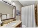 Bathroom featuring a large vanity, framed mirror, tan walls, and a bathtub with a shower at 2318 Willington Shoals Se Pl, Smyrna, GA 30080