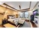 Comfortable bedroom featuring tray ceilings, hardwood floors, and a cozy sitting area with stylish decor at 2318 Willington Shoals Se Pl, Smyrna, GA 30080