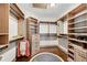 Walk-in closet boasts custom wood shelving, drawers, and ample space for organization and storage at 2318 Willington Shoals Se Pl, Smyrna, GA 30080