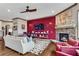 Cozy living room with brick fireplace and built-in shelving, accented by a modern red accent wall at 2318 Willington Shoals Se Pl, Smyrna, GA 30080