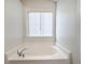 A soaking tub sits under a window in this clean and bright bathroom at 3165 Bellestone Ct, Marietta, GA 30066