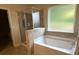 Modern bathroom featuring a soaking tub, tile surround, and a separate glass-enclosed shower at 3831 Village Crossing Ln, Ellenwood, GA 30294