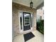 Charming brick entryway featuring a black front door with sidelights and a stylish overhead light fixture at 3831 Village Crossing Ln, Ellenwood, GA 30294