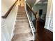 Carpeted staircase with wooden handrail and wrought iron balusters leading to the upper level at 3831 Village Crossing Ln, Ellenwood, GA 30294