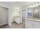 Bright main bathroom featuring granite counters, dual sinks, walk-in closet, and gray wood-look flooring at 1462 Stephens View Dr, Loganville, GA 30052