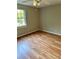 This bedroom features hardwood floors, neutral walls, a ceiling fan, and a window providing natural light at 2574 Stratford Ln, Morrow, GA 30260