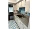 A kitchen featuring white cabinets, laminate countertop, tile walls with accents, and a white and blue checkered floor at 2574 Stratford Ln, Morrow, GA 30260
