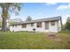 Backyard with a white brick house, green grass, and tree stump at 4647 Wonder Valley Trl, Decatur, GA 30034