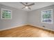 Empty bedroom features hardwood floors, ceiling fan, and two bright windows at 4647 Wonder Valley Trl, Decatur, GA 30034