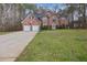 Traditional brick home with a well-manicured front lawn and an extended driveway at 504 Trotters Ln, Mcdonough, GA 30252