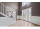 Bright foyer with a white staircase, light wood floors, and high ceilings at 504 Trotters Ln, Mcdonough, GA 30252
