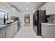 Modern kitchen with white cabinets, stainless steel appliances, and marble tile floors at 504 Trotters Ln, Mcdonough, GA 30252