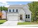 Charming two-story home boasts a welcoming front porch and attached two-car garage at 104 Cedar Brook Dr, Holly Springs, GA 30115