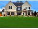 Charming two-story home with a well-manicured green lawn and a mix of stone and siding accents at 1381 Stephens View Dr, Loganville, GA 30052