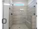 Large walk-in shower features a glass enclosure, built-in bench, and neutral tile at 1693 Juniper Berry Way, Loganville, GA 30052