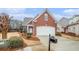 Charming two-story red brick home with a manicured lawn and a two-car garage at 1550 Woodberry Run Dr, Snellville, GA 30078