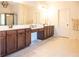 Well-lit bathroom features double vanity with dark wood cabinets, large mirror, and tile flooring at 4025 Toulon Ln, Cumming, GA 30040