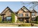 Traditional brick home with stone accents features a manicured lawn, mature trees, and covered porch at 4025 Toulon Ln, Cumming, GA 30040