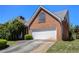 Charming brick home featuring an attached garage, a well-manicured lawn, and architectural details at 4484 Hunters Way, Stone Mountain, GA 30083