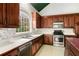 Well-lit kitchen featuring dark wood cabinets, stainless steel appliances, and ample counter space at 4484 Hunters Way, Stone Mountain, GA 30083