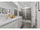 Modern bathroom featuring double sinks, white cabinetry, grey tile flooring and glass enclosed shower at 604 Devon Aly, Acworth, GA 30102