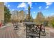 Outdoor living with a spacious back deck featuring elegant iron furniture, area rug, and tree views at 2088 Skybrooke Ct, Hoschton, GA 30548