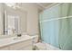 Bright bathroom showcases a vanity with a large mirror and a shower/tub combo with a blue shower curtain at 2088 Skybrooke Ct, Hoschton, GA 30548