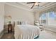 Cozy bedroom features a ceiling fan, a plush bed and chair, with natural light streaming through the windows at 2088 Skybrooke Ct, Hoschton, GA 30548