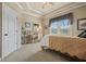 Bright bedroom features a desk, cozy carpet and a white door, with natural light streaming through the windows at 2088 Skybrooke Ct, Hoschton, GA 30548
