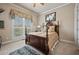 Comfortable bedroom showcasing a wooden bed frame, soft carpet, and a large window for natural light at 2088 Skybrooke Ct, Hoschton, GA 30548