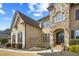 Close-up of a brick and stone home featuring an arched doorway and manicured landscaping at 2088 Skybrooke Ct, Hoschton, GA 30548