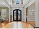 Grand foyer with hardwood floors, arched doorways, and an ornate wrought iron front door at 2088 Skybrooke Ct, Hoschton, GA 30548