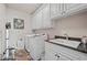 Functional laundry room featuring a sink, storage cabinets, and a washer/dryer at 2088 Skybrooke Ct, Hoschton, GA 30548