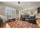 Cozy living room features hardwood floors, leather chairs, and a large window providing ample natural light at 2088 Skybrooke Ct, Hoschton, GA 30548